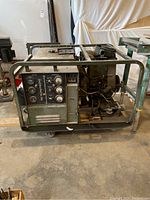 Side view of green steel-framed diesel generator showing control panel and engine