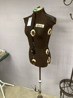 Full view of brown dress form with multiple adjustment dials visible on brown fabric torso and "Diana" label on chest.
