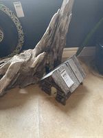 View of the driftwood and rustic birdhouse together on the floor showing overall sizes and textures