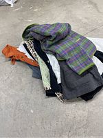 Pile of jackets and blazers showing various styles and colors including plaid, orange, and leopard print