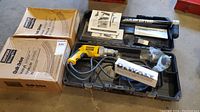 Overall view of Simpson tool, screw boxes, DeWalt screwdriver, manuals in plastic carrying case