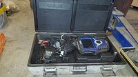 Open hard plastic carrying case showing all contents including cables and diagnostic scanner