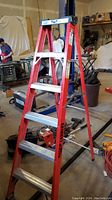 Full view of red Featherlite 6ft step ladder showing entire frame and aluminum steps