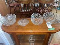 Five crystal bowls and candy dish set displayed on a wooden surface, showing size and pattern variations.