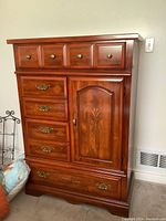 Full front view of the solid wood dresser armoire showing drawers and cabinet door with metal pulls.