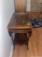Full view of the wood tea wagon including visible drop leaves and bottom shelf with turned legs on casters.