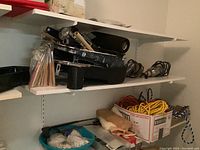 Shelves containing painting supplies, hardware items, rollers, brushes, and electrical cords neatly organized.