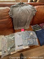 Grey short sleeve polo shirt hung on couch