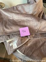 Close up view of grey/brown velvet fabric curtain panel with 96 inch measurement note.