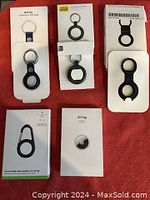 Apple AirTag and key rings new in packaging laid on table.
