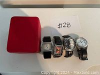 Four men's watches and a red watch case arranged on white surface with lot number #28.