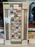 Front view of framed print wrapped in protective film with dimension label 28″ x 15.5″