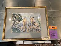 Framed print showing men bathing near trees, gold frame with matte border.
