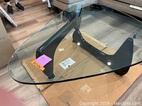 Angled view of glass top and black curved base assembled