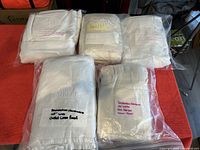 Five packaged curtain panels arranged on red surface.