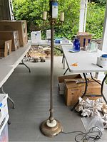 Full view of the antique floor lamp standing on porch with marble base and three light sockets.