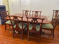 Full view of rectangular mahogany dining table with three leaves and eight chairs