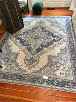 Full view of the large rectangular Surya area rug on wooden floor showing central medallion and border.