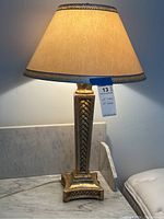 Full view of the table lamp showing base design, lit shade, and height.