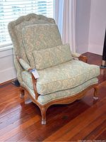 Full view of the vintage Kroll armchair showing its floral fabric upholstery and decorative wooden frame.
