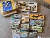 Overhead view of 12 boxed model kits on carpet