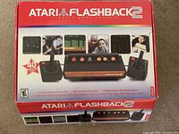 Front of the Atari Flashback 2 box showing the console and two joysticks with branding and features.