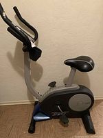 Side view of Pro-Form XP 185U exercise bike showing frame, seat, pedals, and base stabilizers.
