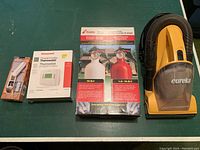 Full shot of all items together: two Kidde fire extinguishers in box, Honeywell thermostat in box, Eureka vacuum, key safe thermometer.