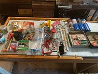 Photo of assorted hardware, propane tanks, storage hooks, and tools laid out on table