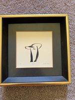 Frontal view of framed print titled "Duet" showing black and gold frame and image of abstract stylized forms.