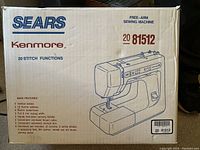 Box front showing the model number 81512 and description of main features including vertical bobbin, 12 built-in stitches, built-in buttonholer, full 5 mm zigzag width, and included accessories such as bobbins, screwdrivers, accessory feet, brush, and darning plate.