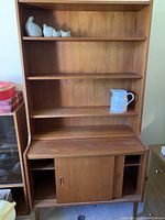 Full view of teak veneer cabinet showing upper shelving, pull-out top surface, lower sliding-door cabinet