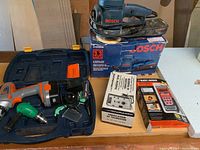 Overview of all four tools including cases and boxes on wooden surface