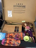 Liv dolls lying inside folded playset with clothing items