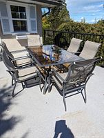 Full view of large dining table with six chairs on patio deck