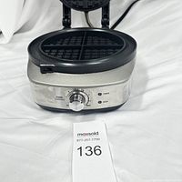Front view of Breville waffle maker showing control dial, power and ready lights, stainless steel and black plastic body.