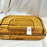 Full view of the double-sided cutting and carving board showing the carved and grooved areas and overall size.