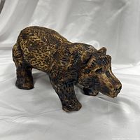 Side view showing the full rustic textured surface of the ceramic bear figurine.