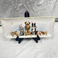 Front view of the rectangular platter with colorful dog illustration and Easter decorations on display stand.
