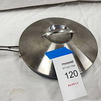 Top view of stainless steel lid on the saute pan, showing handle and finish.