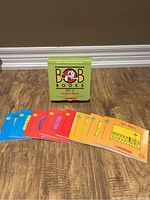 Full front view of the green box labeled 'BOB Books Set 4 Complex Words' with 8 colorful children's books laid out in front showing different cover illustrations.