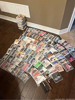 CDs spread on floor in rows, showing album covers and CDs in jewel cases and plastic sleeves