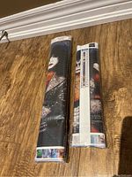 Two rolled KISS diamond art kits in original plastic packaging showing pixelated images of band members.