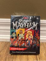 Front view of new and sealed Dungeons & Dragons Dungeon Mayhem card game box showing cartoon characters and game details.