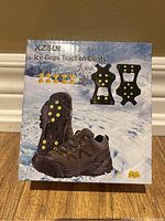 Front photo of the Ice Grips traction cleats box showing the product labeled XZSUN and images of the cleats with metal spikes attached to shoe soles.