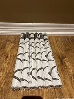 Six rolls of peel and stick wallpaper, new, stacked together showing wallpaper pattern and packaging.