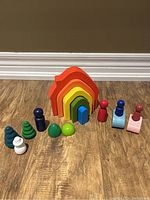 Full set of wooden nesting toys including the rainbow stacker, small wooden figures, and wooden shapes.