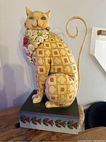 Side view of the large Jim Shore cat figurine showing geometric pattern and floral scarf detail