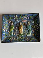Full view of rectangular cloisonné enamel trinket dish with three human figures and floral motifs on blue background.