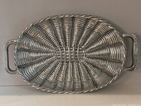 Full view of the oval pewter serving tray showing basket weave pattern and handles